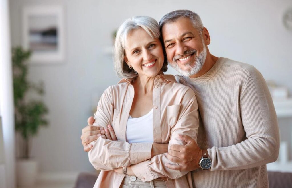 A smiling older couple embracing.