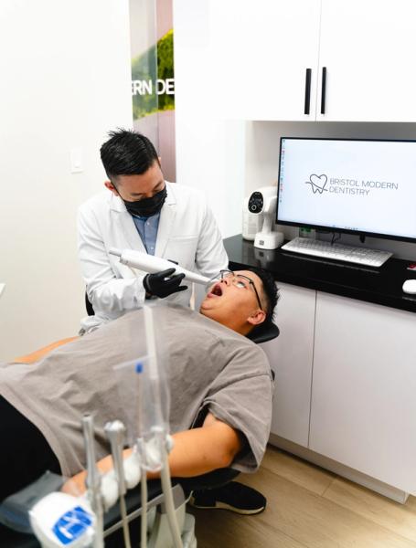 A dentist performs an intraoral scan on a patient in a modern dental office.